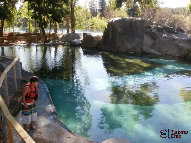 Niño con chaleco salvavidas en la piscina natural de roca del camping